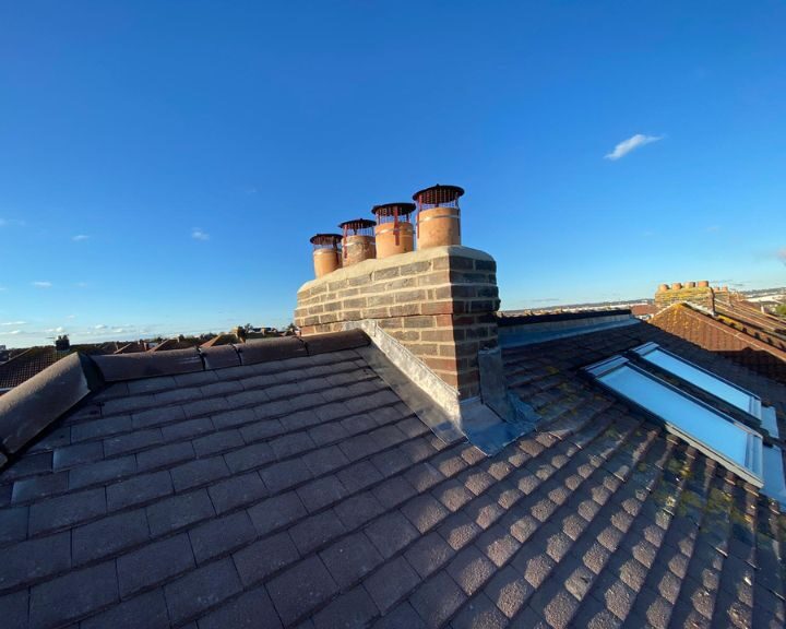 Chimney on a residential roof that has been repaired with new lead flashing